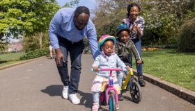 Family Teaching Children To Ride A Bike Landscape