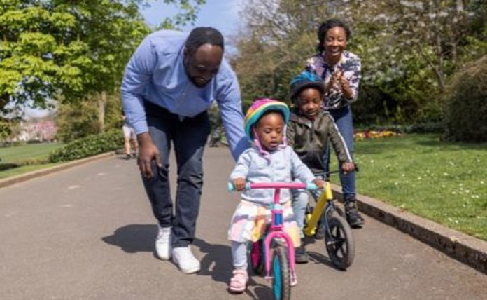 Family Teaching Children To Ride A Bike Landscape