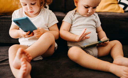 two young children on devices