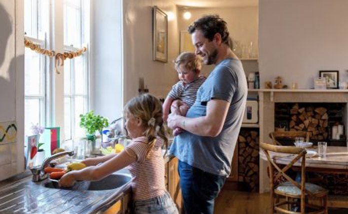 Father With Baby Watching Young Daughter With Chores Landscape