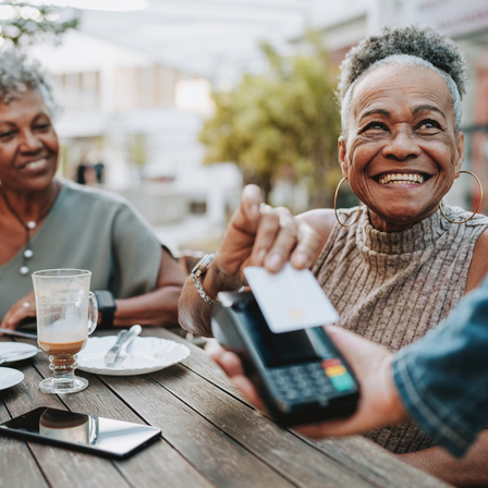 Older lady paying for her meal using contactless payment