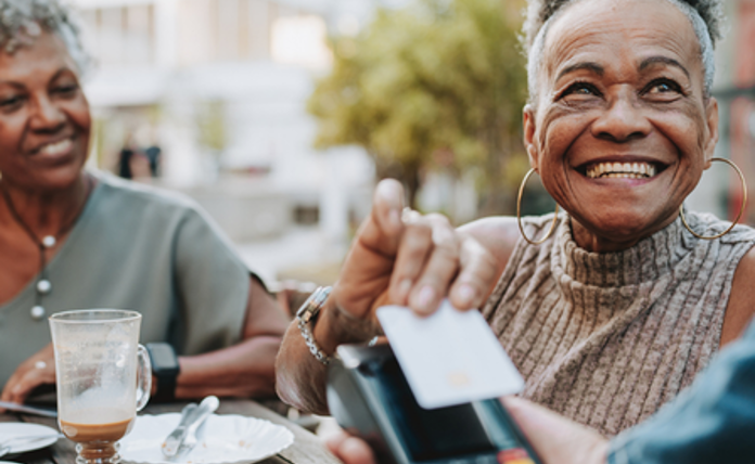 Older lady paying for her meal using contactless payment