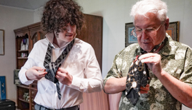 Grandson And Grandad Learning To Tie A Tie
