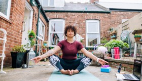 Woman doing yoga outside in her garden