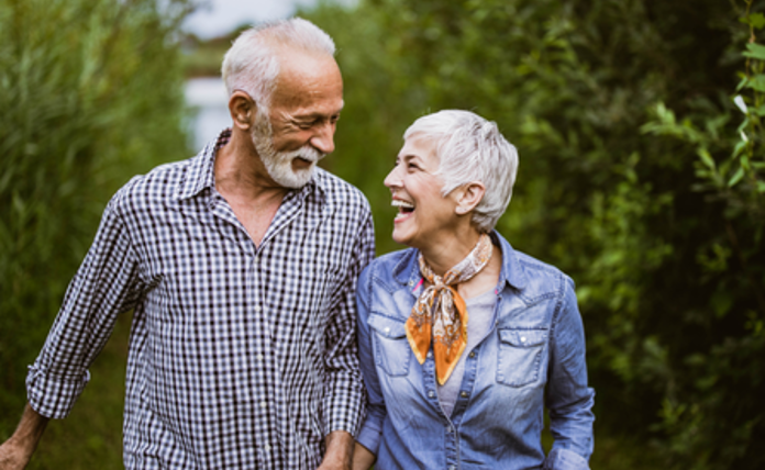 Mature Couple Laughing On Walk Landscape