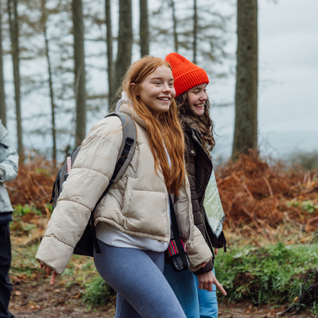 two teenage girls walking through the woods